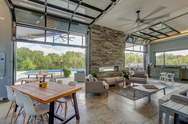 interior space featuring ceiling fan, a stone fireplace, and sink