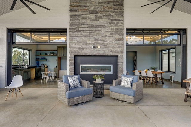 living room featuring high vaulted ceiling, sink, and concrete flooring