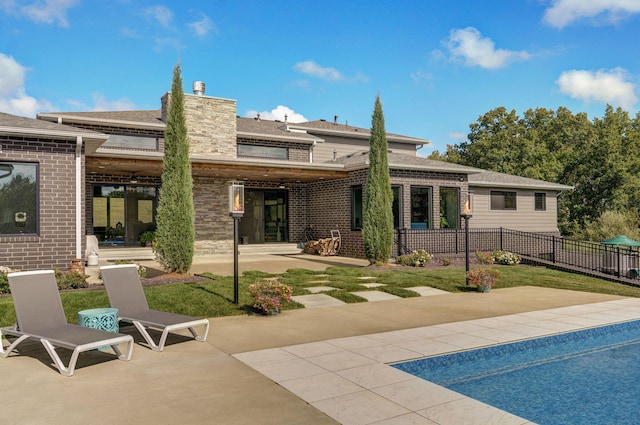 rear view of property with a lawn and a patio