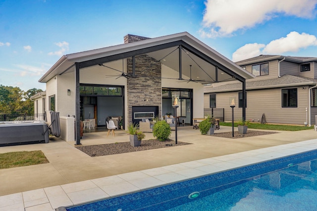 rear view of house featuring ceiling fan and a patio area