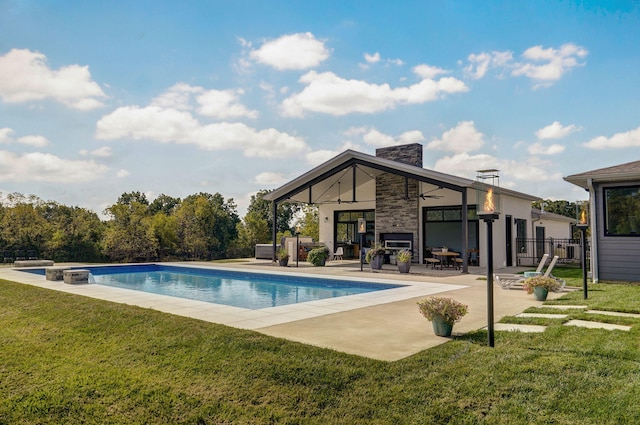 view of pool with ceiling fan, a lawn, and a patio area