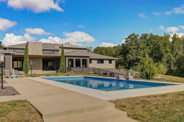 view of pool with a lawn and a patio area