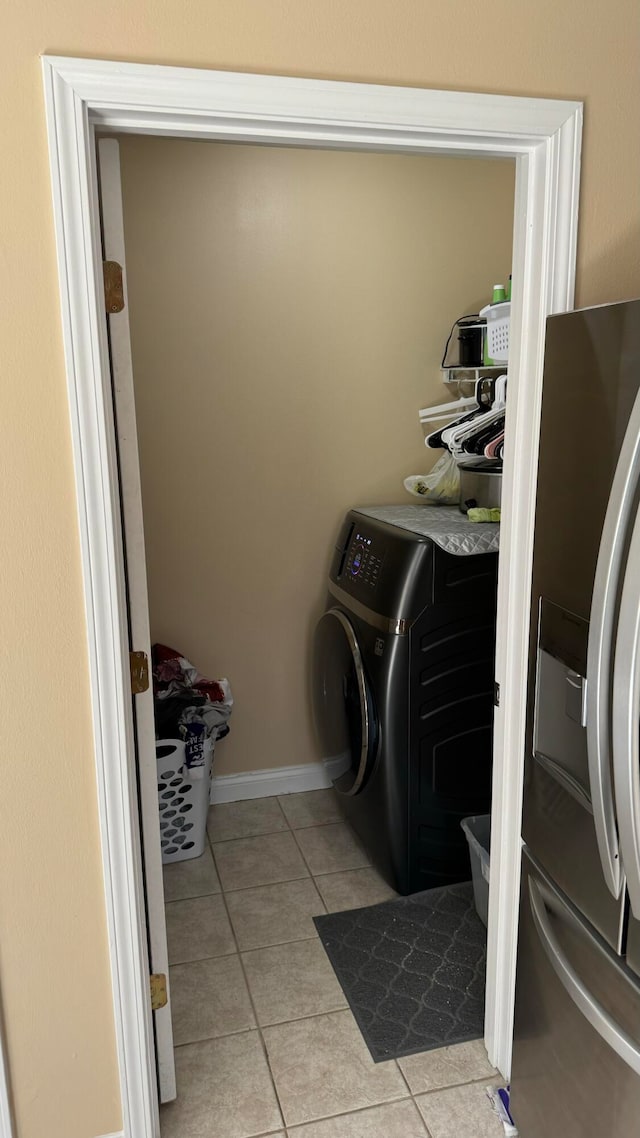 washroom with washing machine and dryer and light tile patterned floors