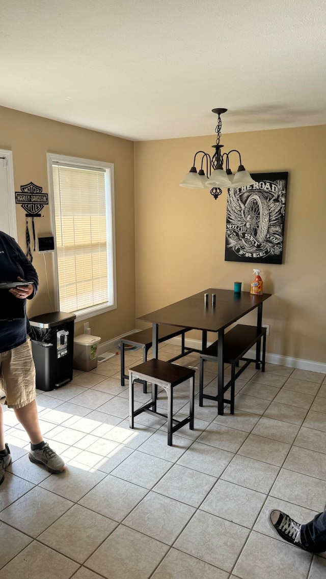 dining room with light tile patterned flooring and a chandelier