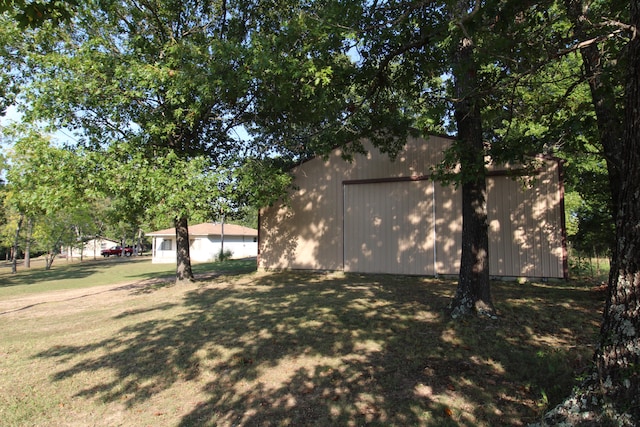 view of side of property featuring an outbuilding and a lawn