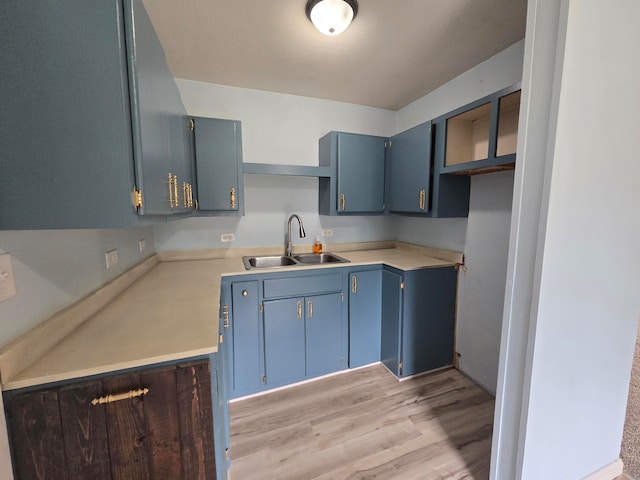 kitchen with light hardwood / wood-style floors, blue cabinets, and sink