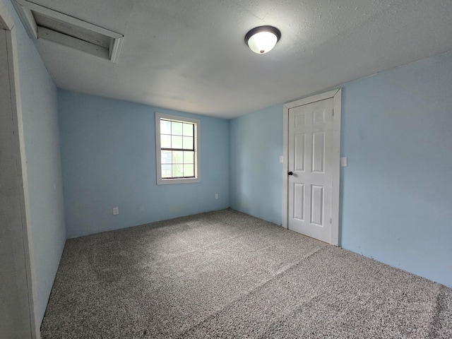 carpeted spare room featuring a textured ceiling