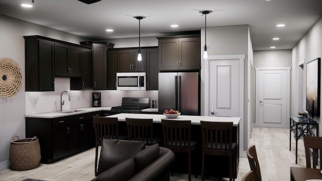 kitchen featuring a sink, light wood-style floors, light countertops, appliances with stainless steel finishes, and a kitchen island