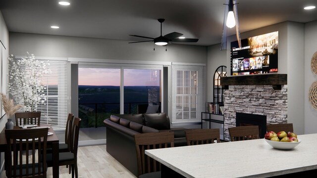 living room with light wood-type flooring, a fireplace, and ceiling fan