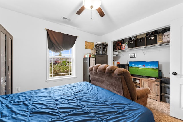 carpeted bedroom with ceiling fan and a closet