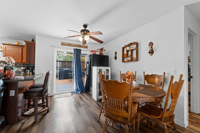 dining space with ceiling fan and dark wood-type flooring