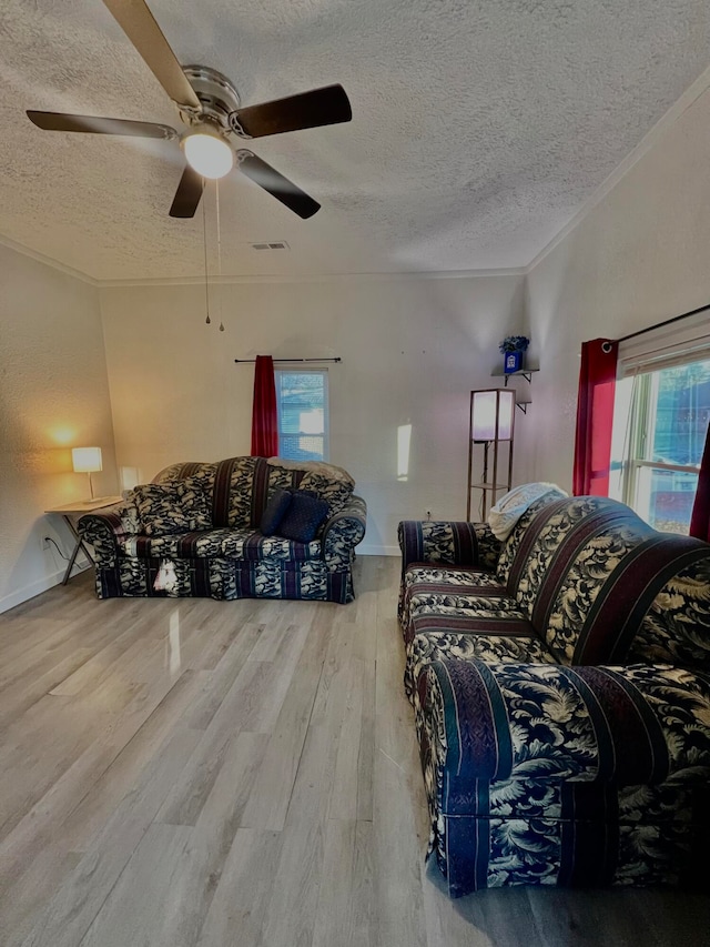 living room with a wealth of natural light, a textured ceiling, and hardwood / wood-style flooring