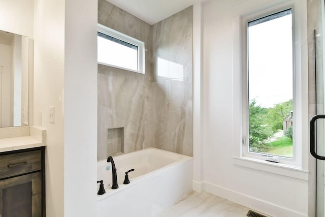 bathroom featuring vanity, plus walk in shower, and a healthy amount of sunlight