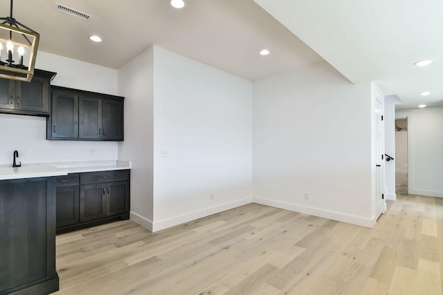 kitchen with pendant lighting, a chandelier, and light hardwood / wood-style floors