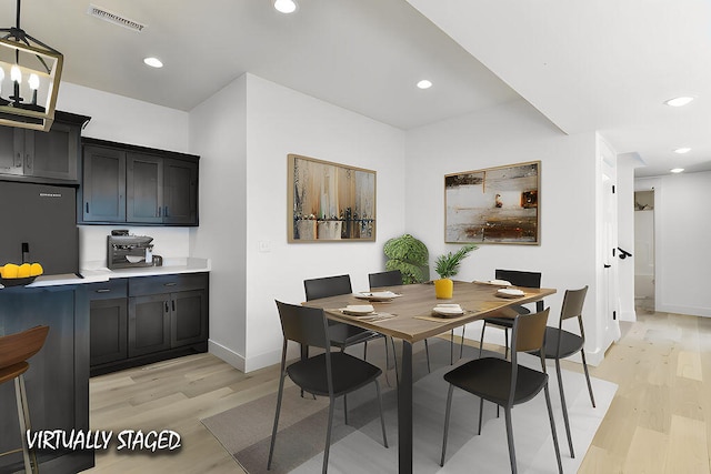 dining area featuring light hardwood / wood-style floors and an inviting chandelier