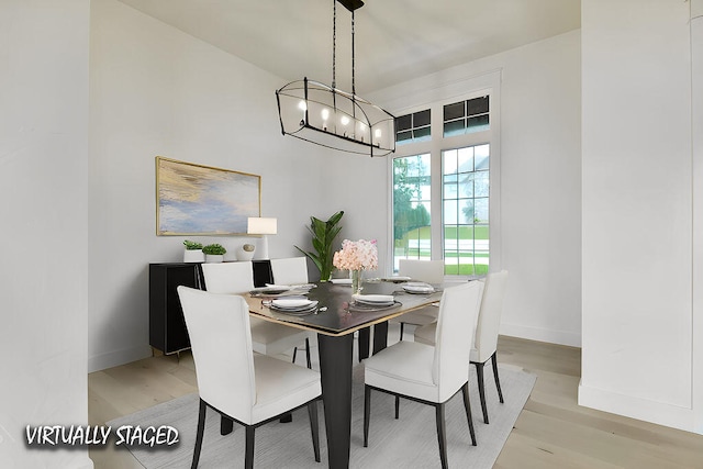 dining area with an inviting chandelier and light hardwood / wood-style floors