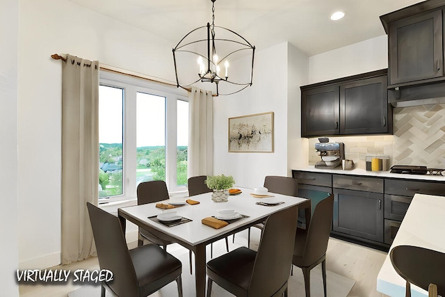 dining space with an inviting chandelier and light hardwood / wood-style floors