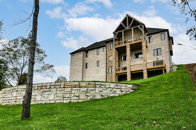 back of property with a balcony and a lawn