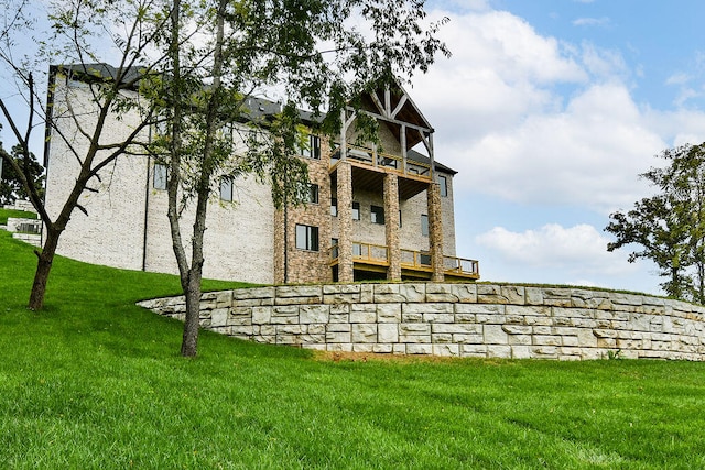 rear view of property with a yard and a balcony