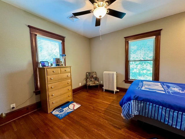 bedroom featuring ceiling fan, dark hardwood / wood-style floors, and radiator heating unit