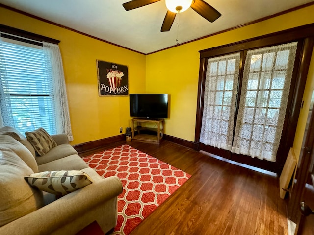 living room with ornamental molding, ceiling fan, and dark wood-type flooring