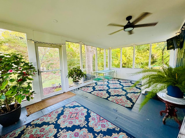 unfurnished sunroom featuring ceiling fan