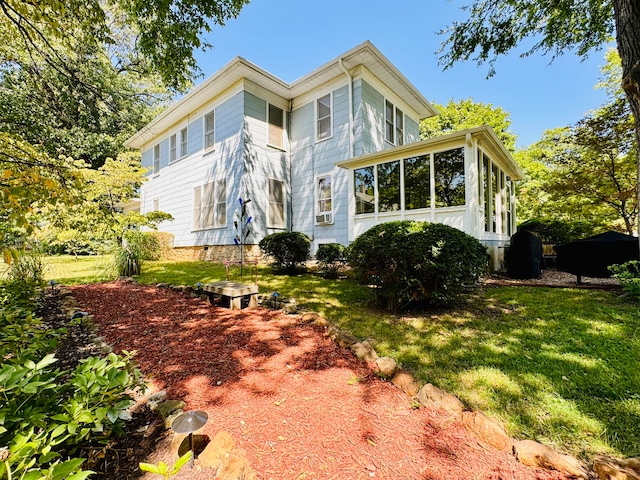 back of house with a lawn and a sunroom