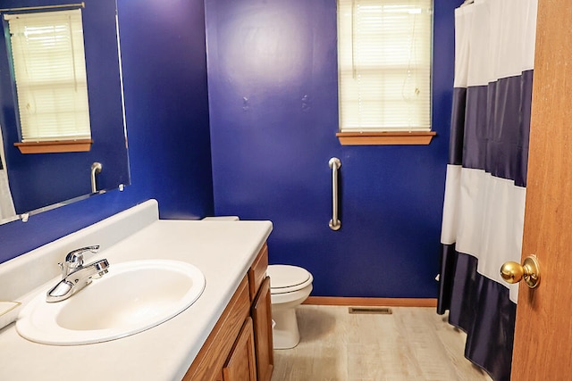 bathroom with hardwood / wood-style floors, toilet, and vanity