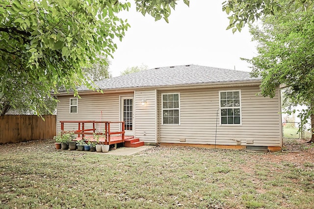 back of house featuring a wooden deck and a yard