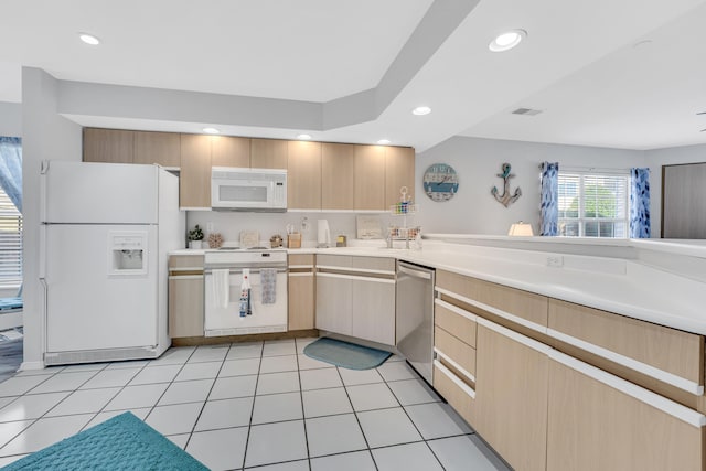 kitchen with light brown cabinetry, light tile patterned floors, and white appliances