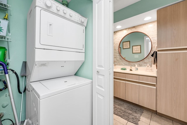 laundry area with light tile patterned floors and stacked washer / drying machine