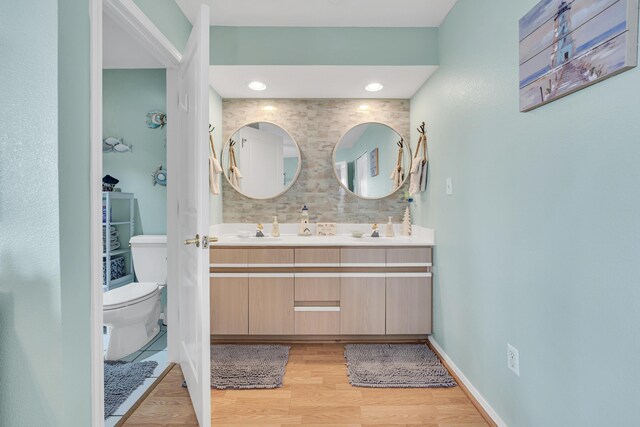 215 Meadow Brook Ln Unit 1, Branson, MO 65616 - bathroom featuring double vanity, wood finished floors, toilet, and a sink