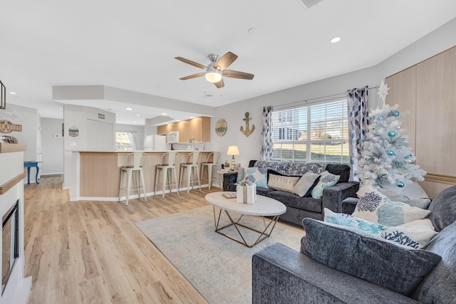 living room featuring light hardwood / wood-style flooring and ceiling fan