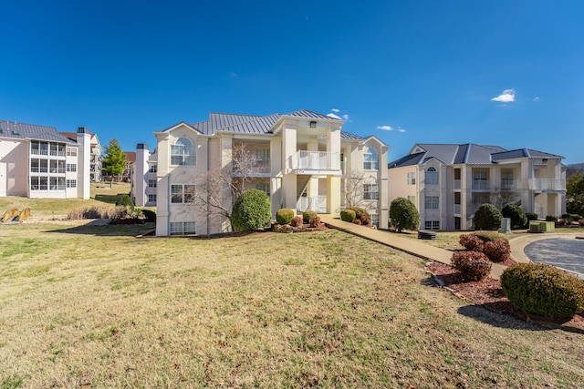 exterior space featuring a front yard and a balcony