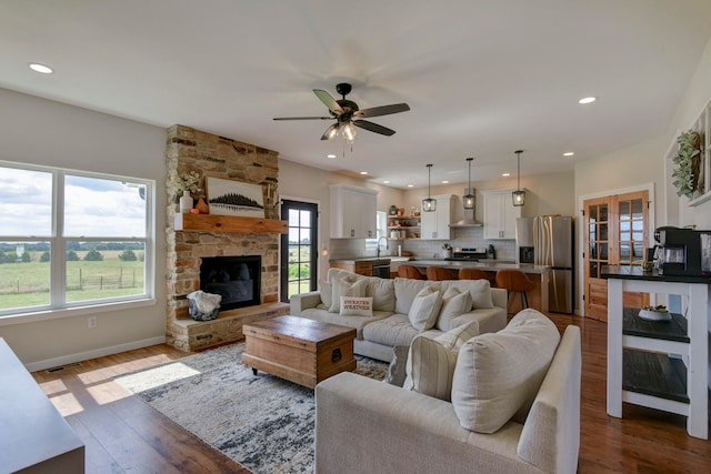 living room featuring wood-type flooring, sink, a wealth of natural light, and ceiling fan