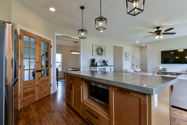 kitchen featuring french doors, decorative light fixtures, appliances with stainless steel finishes, and dark wood-type flooring