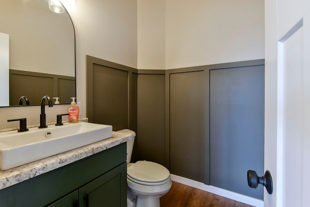 bathroom with hardwood / wood-style floors, vanity, and toilet