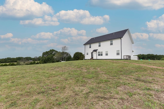 rear view of property featuring a rural view and a yard