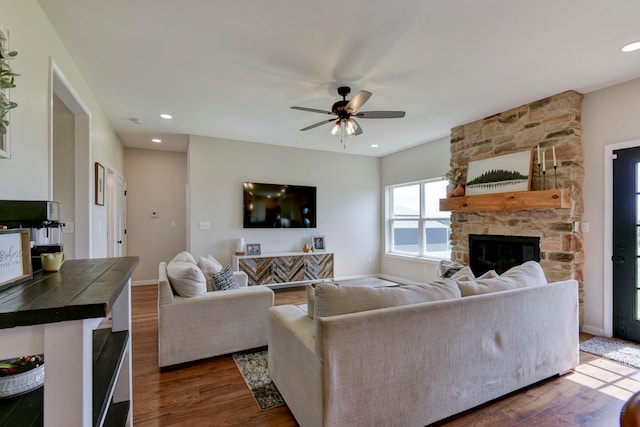 living room with ceiling fan, a fireplace, and dark hardwood / wood-style flooring