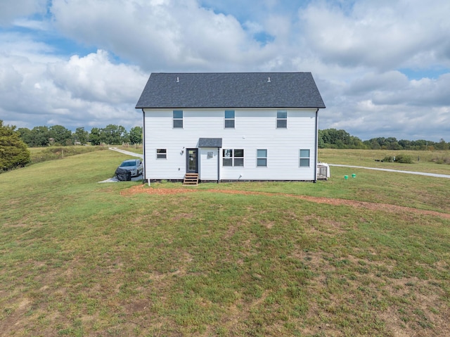 rear view of property with a lawn