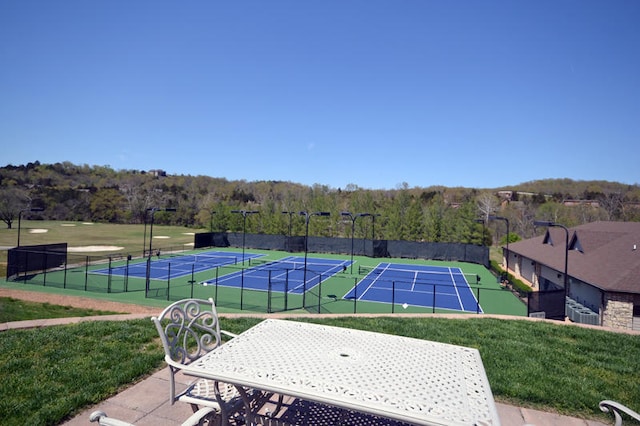 view of tennis court with a lawn