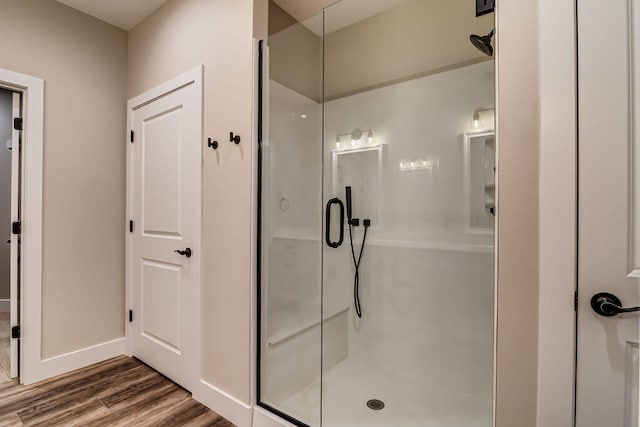 bathroom featuring wood-type flooring and a shower with shower door