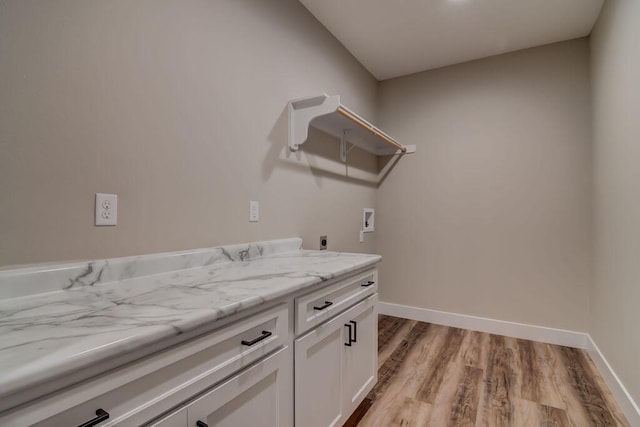 clothes washing area featuring washer hookup, cabinets, light wood-type flooring, and electric dryer hookup