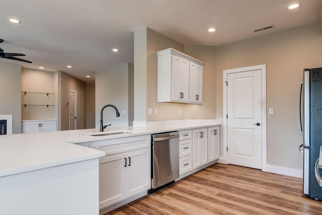 kitchen featuring ceiling fan, light hardwood / wood-style flooring, sink, appliances with stainless steel finishes, and white cabinetry