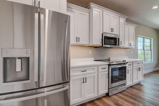 kitchen featuring appliances with stainless steel finishes, white cabinetry, and light hardwood / wood-style flooring