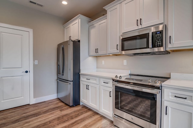 kitchen featuring white cabinets, stainless steel appliances, and light hardwood / wood-style floors