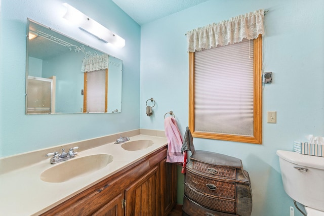 bathroom featuring vanity, toilet, and a textured ceiling