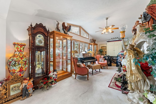 sitting room with ceiling fan, light colored carpet, and vaulted ceiling