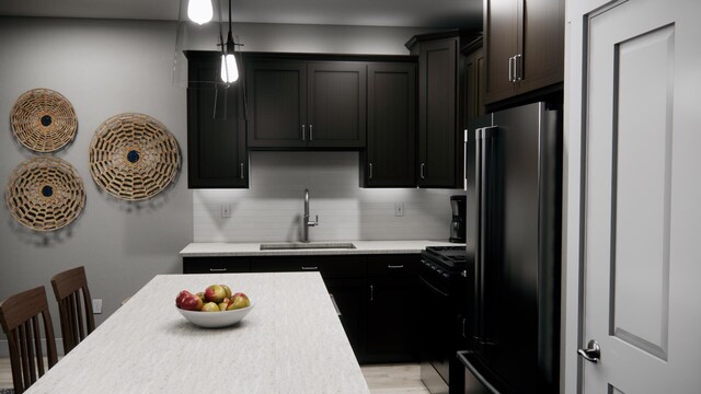 kitchen featuring stainless steel fridge, sink, decorative light fixtures, black range, and decorative backsplash