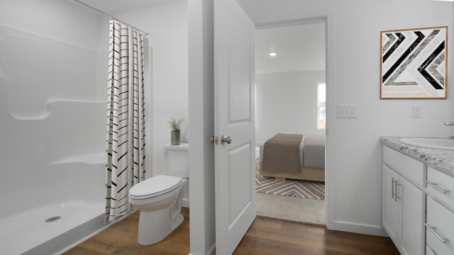 full bathroom featuring a shower stall, wood finished floors, toilet, and vanity
